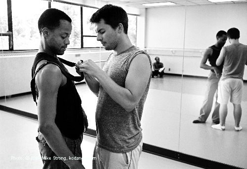 A persistent costume problem - Here choreographer Josh Beamish is adjusting Chris Barksdale's suspender which kept unsnapping in rehearsal - in UMKC annex studio room. - photo Mike Strong kcdance.com